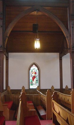 Photo of interior wooden arch and pews